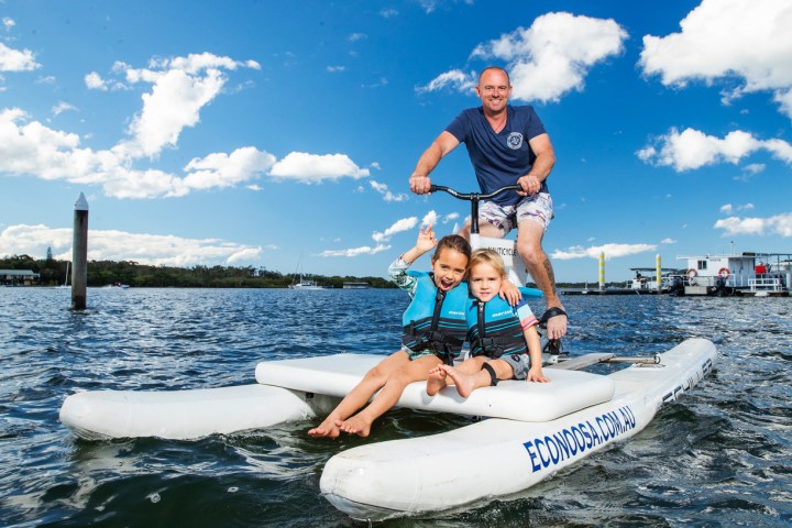 a man riding on the back of a boat in a body of water