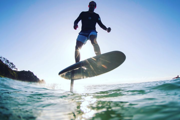 a man flying through the air while riding a wave on a surf board